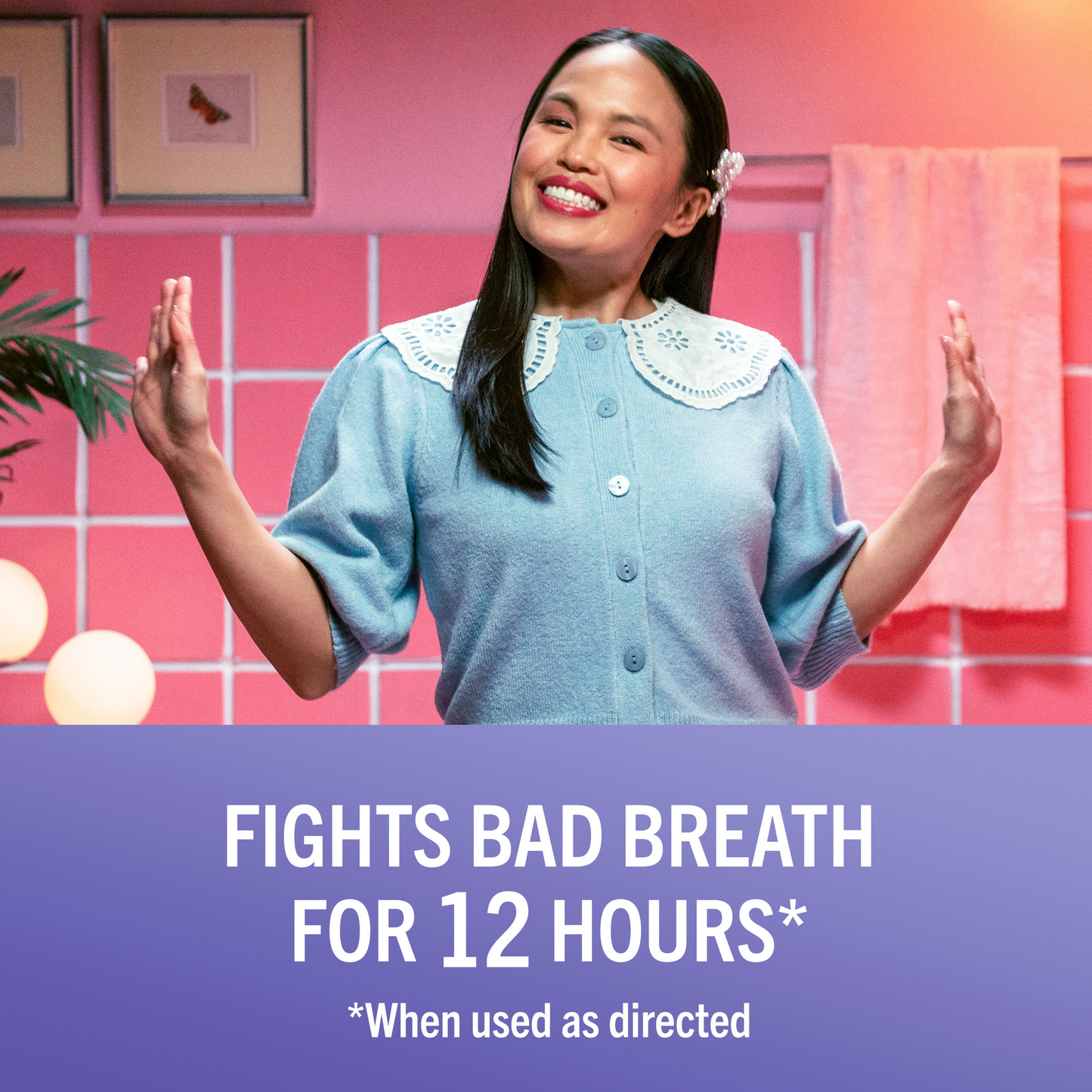 Woman in a bright pink bathroom gargles while holding an orange TheraBreath Oral Rinse cap. Under her image is written "Helps fight plaque & gingivitis for 24 hours when use twice daily as part of an oral care routine."