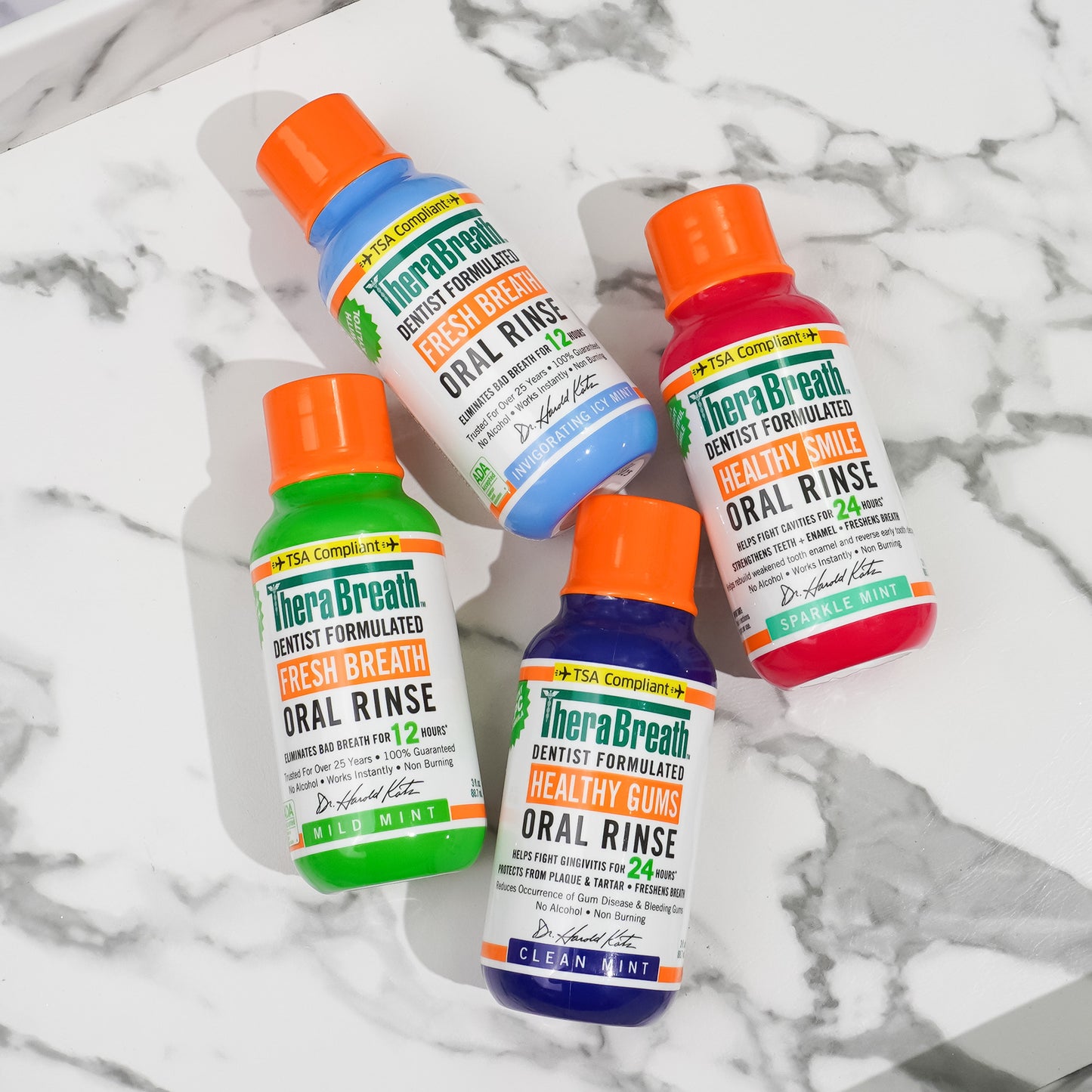 Assortment of TSA-compliant TheraBreath Oral Rinse flavors displayed on a table