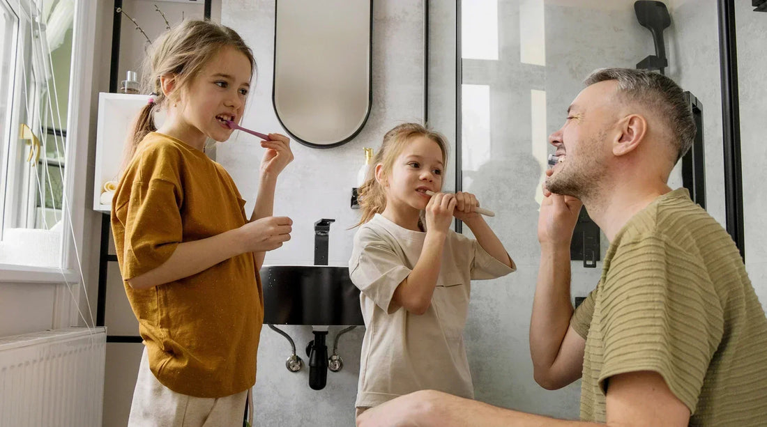 Dad teaching kids proper teeth cleaning at home during a family dental routine