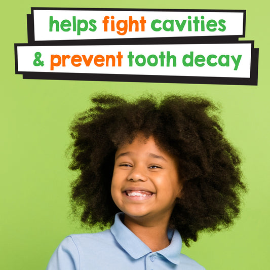 "Helps fight cavities and prevent tooth decay" is stated in green and orange letters with a white background in front of a cute black child in a blue shirt with a big smile. 