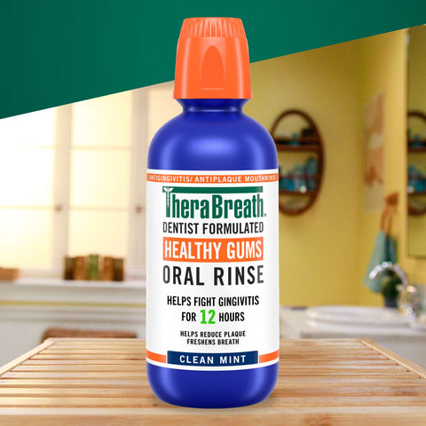 A blue bottle of TheraBreath healthy gums oral rinse in clean mint flavor in the bathroom.