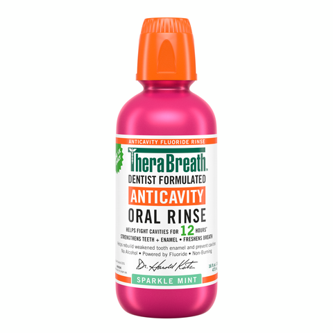 Pink bottle of TheraBreath anticavity oral rinse in sparkle mint flavor on a white background.
