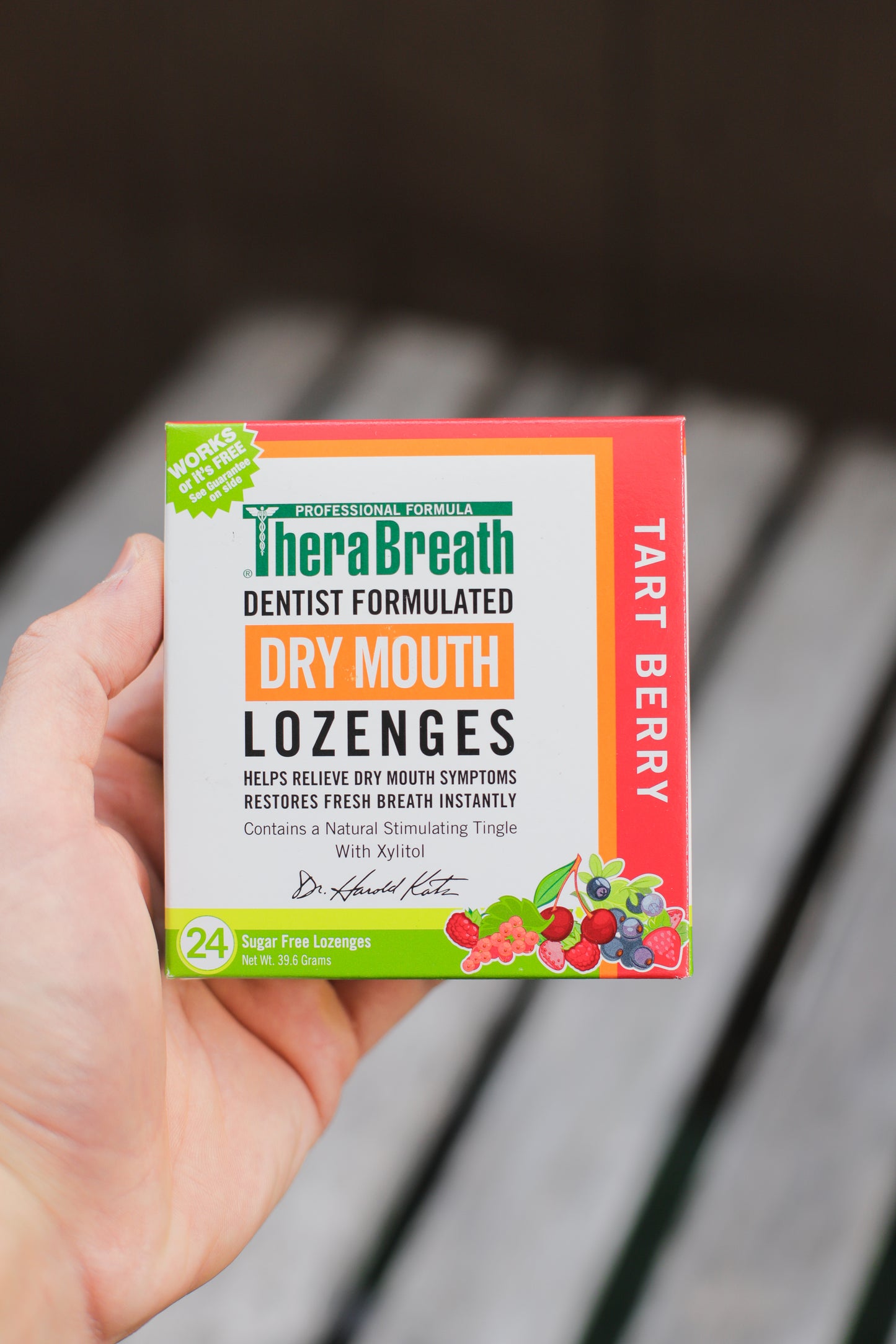Hand holds a box of TheraBreath Dry Mouth Lozenges in Tart Berry. Illustrations of small berries decorate the package.