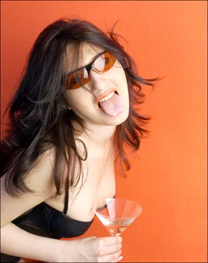 Woman sticking out tongue with martini glass