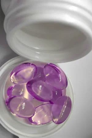 Purple vitamins poured into cap
